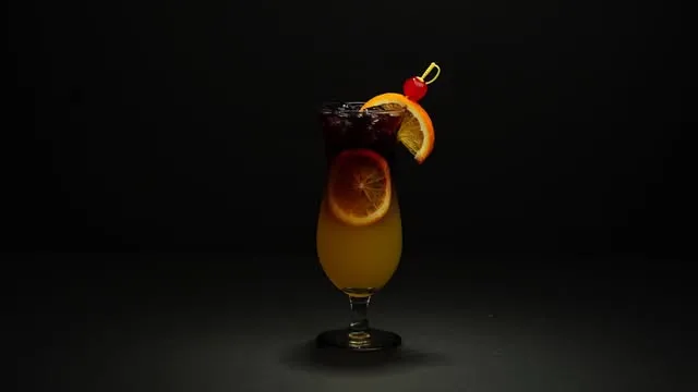 Cóctel con rodaja de naranja y cereza